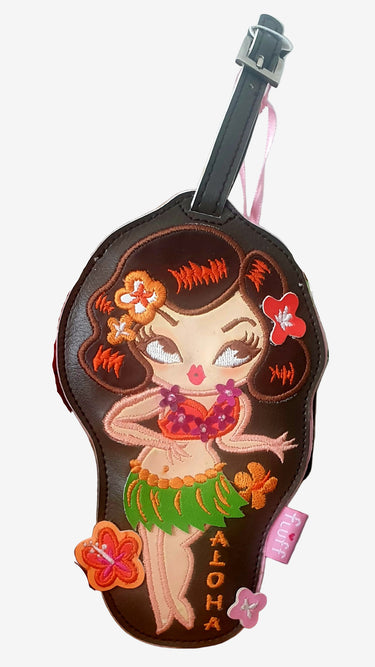 A luggage tag featuring an illustration of a hula dancer with a green skirt and a lei, named 'Aloha'. The tag has a buckle strap for attaching to luggage.