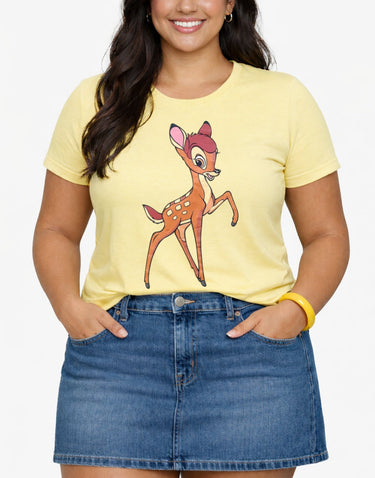 Woman wearing a yellow t-shirt with a cartoon character, standing against a white background