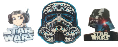 A set of three brooches featuring characters from the Star Wars franchise. From left to right: a brooch of Princess Leia, a brooch of a sugarskull Stormtrooper, and a brooch of Darth Vader.
