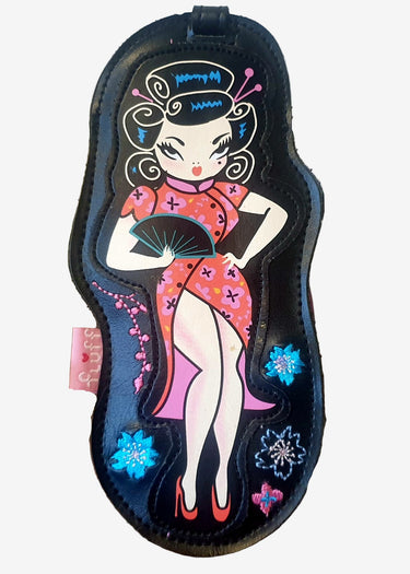 A decorative luggage tag featuring a stylized, colorful illustration of a woman in a traditional Chinese outfit with a floral pattern and red shoes. The tag is attached to a buckle strap.