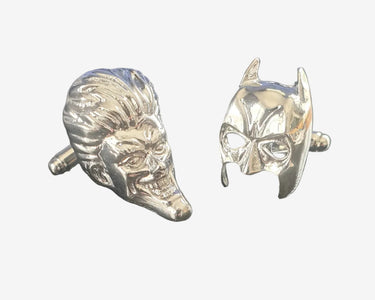 Metallic Batman and Joker mask-shaped cufflinks on a white background
