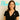 Woman wearing a black top with a small white logo, standing against a beige background with 'Planet Retro' text.