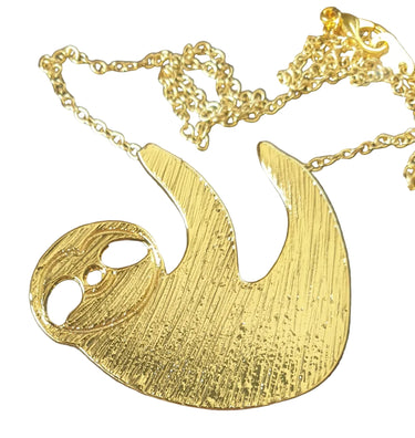 Gold sloth-shaped pendant on a chain against a white background