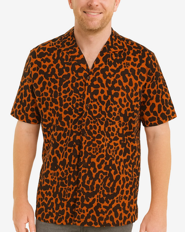 Man wearing a leopard print shirt on a plain background