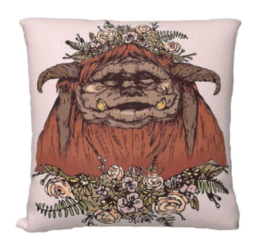 Decorative pillow with a cartoonish creature surrounded by flowers on a white background