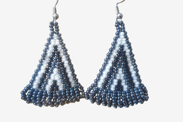 A pair of handmade seed bead earrings with black and white colors, displayed against a white background.