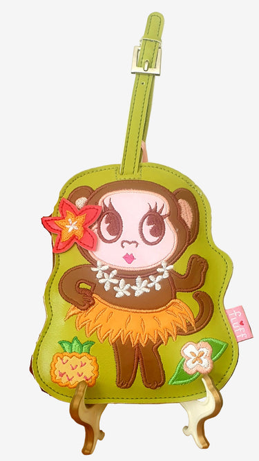 A green luggage tag featuring a cute monkey design with a floral lei and hula outfit