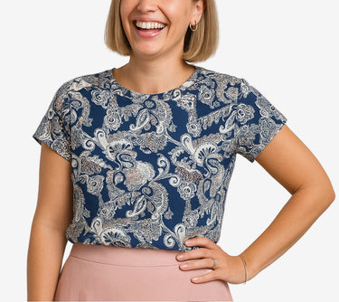 Woman wearing a blue patterned top against a plain background