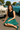 Woman sitting on the ground in front of vintage cars