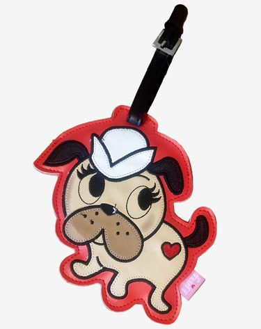 Dog-shaped luggage tag with a white hat on a white background