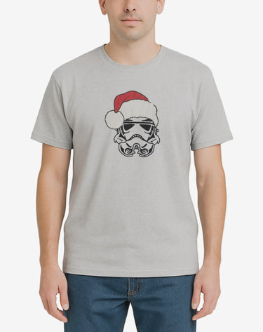 Person wearing a gray t-shirt with a graphic design on a plain background
