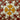 A vintage handpainted ceramic plate with earthy tones, featuring a floral pattern in golden yellow, maroon, brown, and terracotta.
