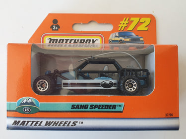 Toy sand speeder in packaging with 'Mattel Wheels' branding on an orange background