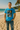 Man wearing a blue t-shirt with a graphic design on a beach