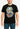 Person wearing a black t-shirt with a colorful graphic design on a plain background