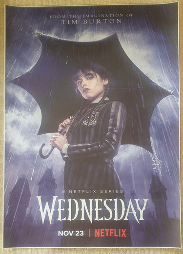 Promotional poster for 'Wednesday' Netflix series with a character holding an umbrella. Planet Retro NZ
