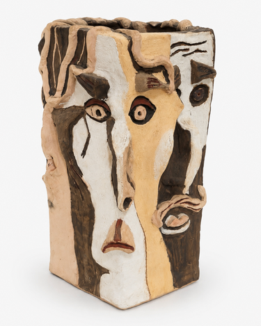 A sculptural ceramic vase with an abstract face design, featuring a textured, hand-painted finish in beige, brown, and white on a clean white background.