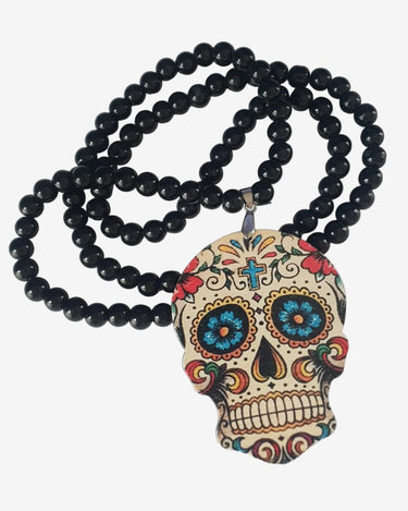 A beaded necklace with a sugar skull pendant, featuring dark black beads and a decorative skull charm with colorful floral and geometric patterns in red, blue, yellow, and white.