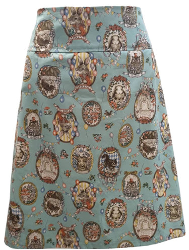 A straight pencil skirt with a woodland animal cameo print in a variety of colors on a light blue background.