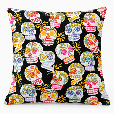 Black Sugar Skulls handmade cushion cover front with colourful floral skull pattern on black, shown filled on light grey studio background