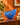 Asymmetrical cobalt-blue swirled art glass bowl displayed on a wooden sideboard against a warm orange wall