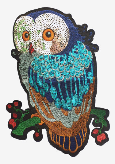 Sequined owl design embroidered patch on a grey background