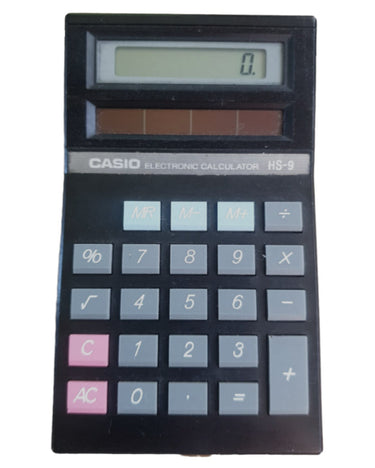 A classic Casio RS-9 electronic calculator with a black plastic body, gray buttons, and pink C and AC buttons, shown against a plain white background.