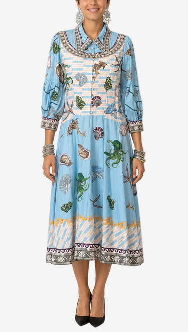 Woman wearing a blue patterned dress on a white background