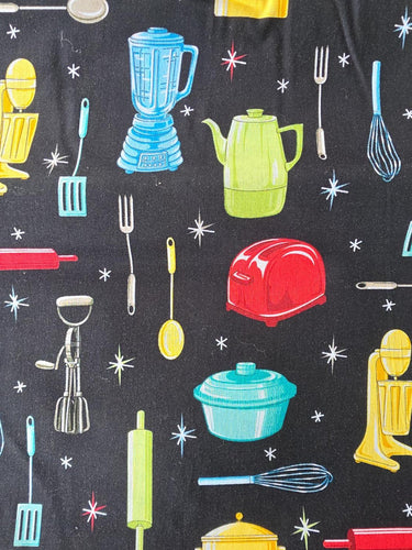 Close-up of retro atomic kitchen fabric with red toaster blue blender and green coffee pot on black