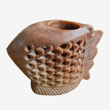 A carved wooden fish-shaped candle holder with a hollow center.