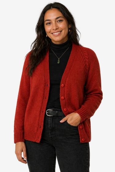 Woman wearing a red cardigan over a black top and pants on a white background