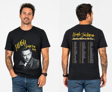 A man modeling a black graphic T-shirt shown from both front and back against a light gray studio background. The front has a black-and-white portrait of Hugh Jackman with yellow text reading 'HUGH World Tour 2019.