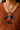 Colorful necklace with a character pendant on a brown shirt