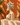 Hand-carved African-style female sculpture styled against an orange wall