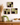 Three square ceramic wall art pieces on a white wall with a wooden cabinet and decorative items below.