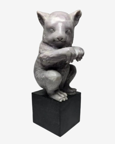 Grey animal sculpture on black plinth, front three-quarter view