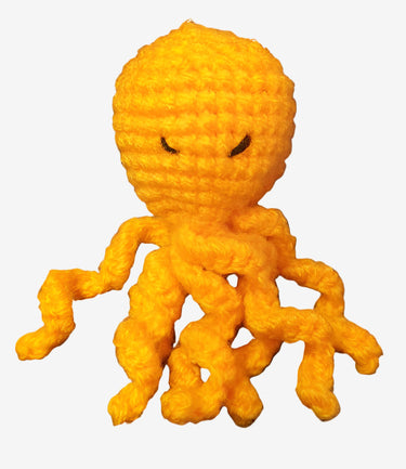 A handcrafted yellow octopus brooch made from yarn, displayed against a white background.