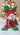 Decorative bear ornament with red coat, green hat and gloves on a white background
