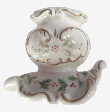 Decorative white candle holder with gold and green floral patterns on a white background