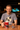 Man holding a mug with a 'Dad' design, sitting at a table with a 'Planet Retro' sign in the background.