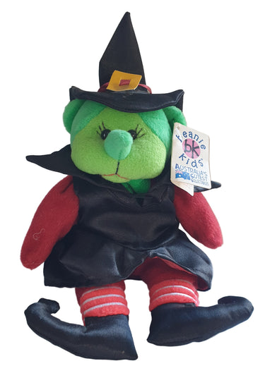 Plush toy resembling a witch with a tag on a white background