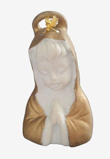 Small figurine of a person in a robe on a textured surface