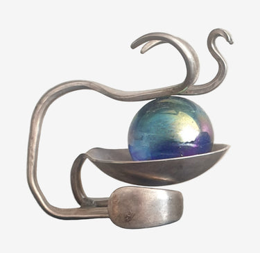 Upcycled EPNS cutlery sculpture featuring an iridescent glass orb in a steampunk-style abstract design.