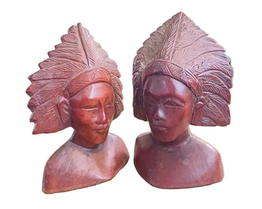 Front view of both small Balinese carved wooden busts with feather-style headdresses