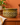 Vintage Beswick Zorba olive-green ceramic large bowl styled against a pale burnt orange wall on a wooden sideboard