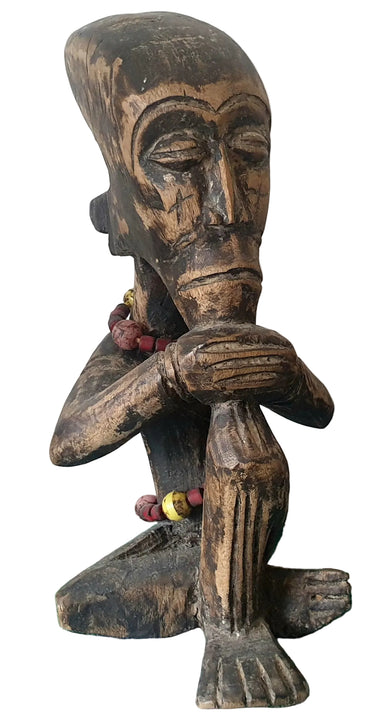 Vintage carved wooden thinking man figure with rustic aged finish and seated pose.