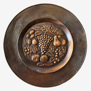 Vintage embossed copper fruit wall plate front view showing raised grapes pears and fruit design