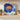 Vintage Japanese square side plate with cobalt blue background, orange floral design and gold rim, displayed on stand