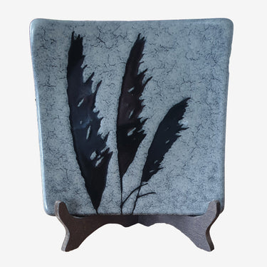Vintage hand-painted New Zealand pottery plate by Chalie Seakins, featuring a feather design and Muriwai black sand glaze.