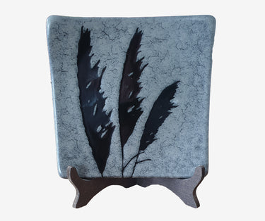Vintage hand-painted New Zealand pottery plate by Chalie Seakins, featuring a feather design and Muriwai black sand glaze.